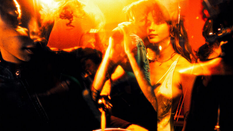 ДОТИК — Performer surrounded by warm orange light and reflections